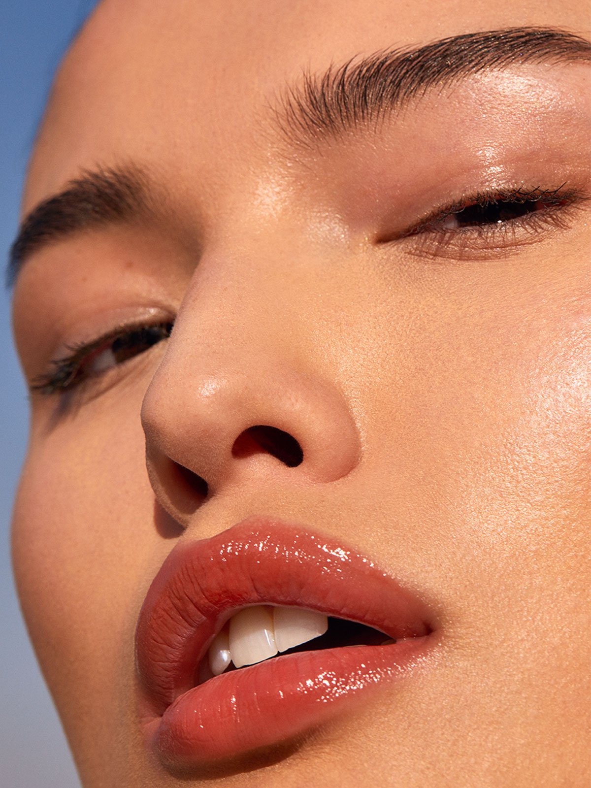 Model wearing ILIA Balmy Gloss Tinted Lip Oil in Shade Saint - AILLEA